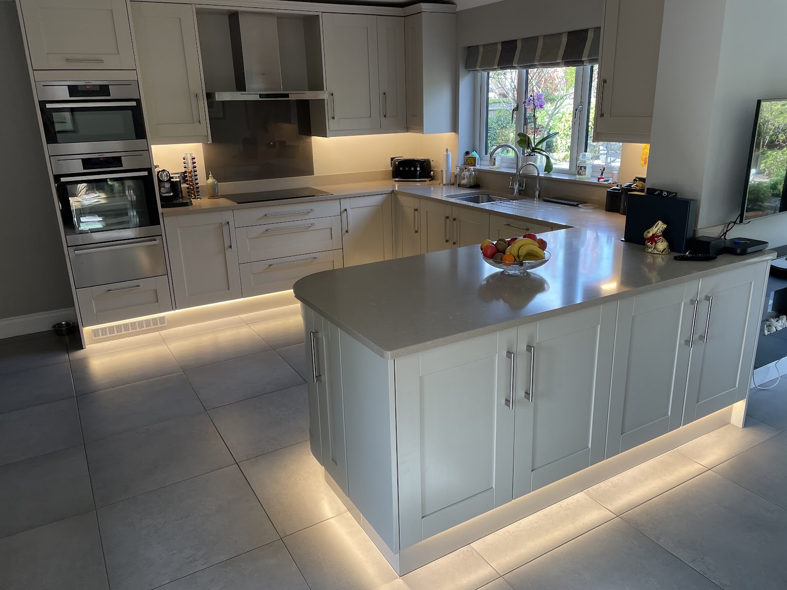 A kitchen with LED plinth lighting and under-cabinet lights