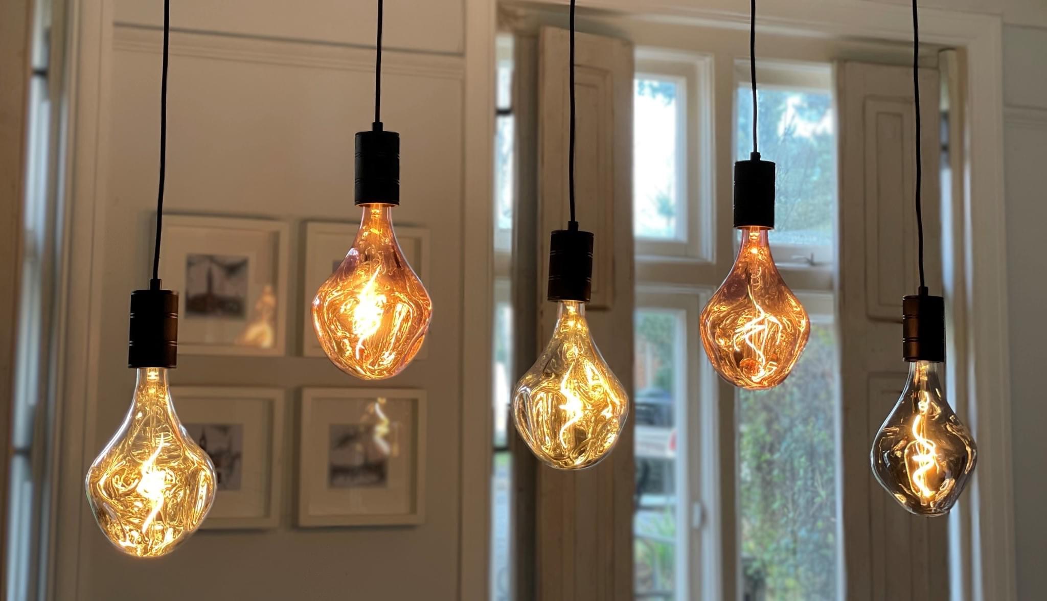 A row of filament pendant bulbs over a dining area
