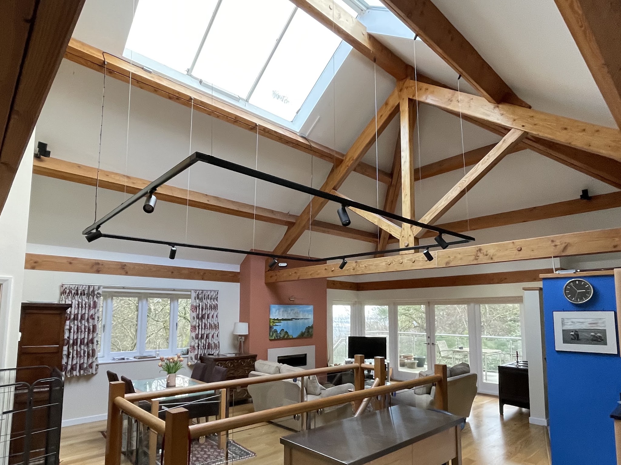 A vaulted oak-beam living space with black track lighting