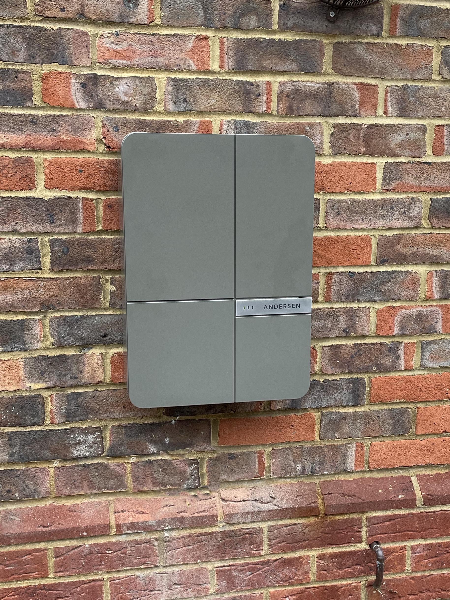A grey Andersen charger on a brick wall