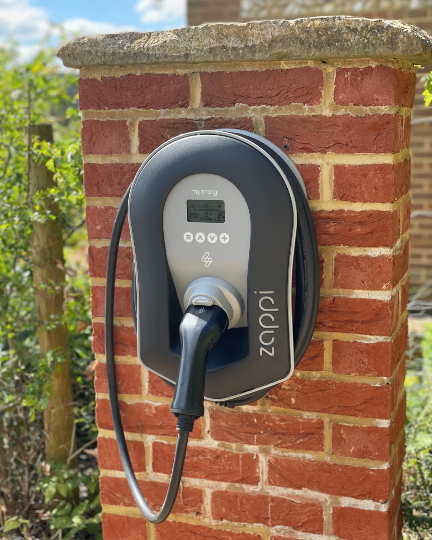 A zappi charger fitted on a brick gate pillar